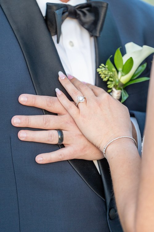 Close-up of bride and groom’s hands with rings