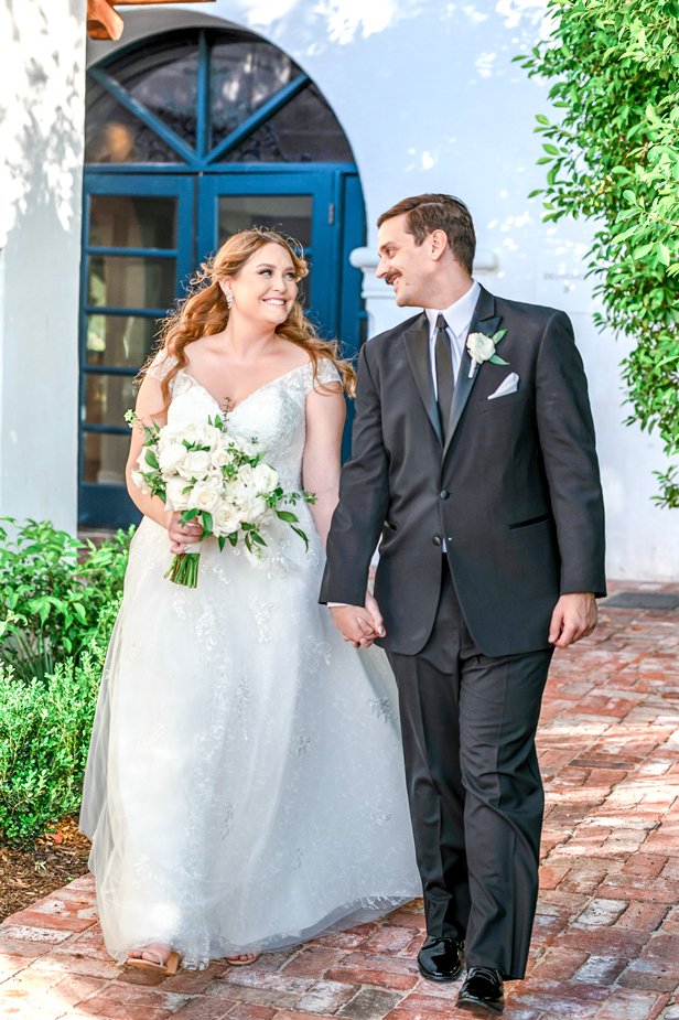 Bride and groom walking hand in hand outside Wrigley Mansion wedding venue