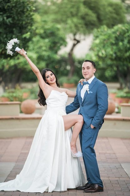 Bride and groom walking together along citrus grove pathway at Fairmont Scottsdale Princess