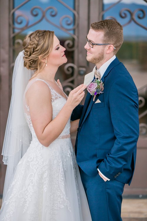 Bride and groom standing face-to-face holding bouquet indoors