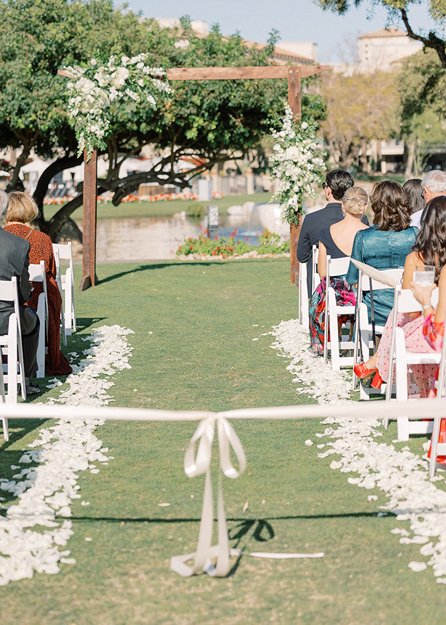 Bride and groom portrait beside lagoon and greenery at Fairmont Scottsdale Princess