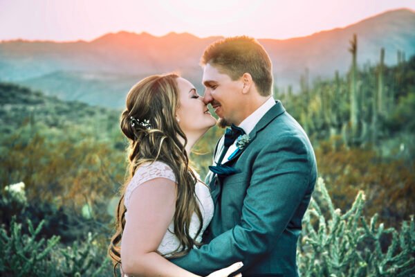 Groom and bride holding each other outdoors