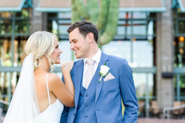 Groom and bride holding each other outdoors