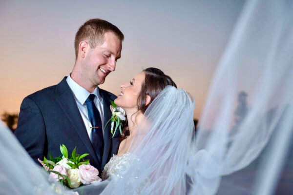 Bride and groom smiling at each other in golden sunset