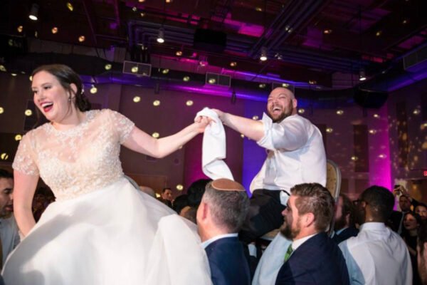 Groom lifted into the air during lively wedding reception