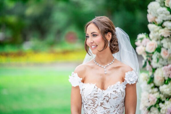 Arizona wedding photographer capturing a bride smiling outdoors with soft greenery behind her.