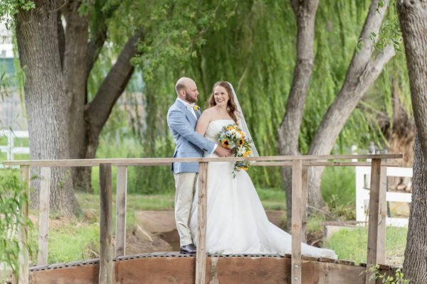 Phoenix wedding photographer capturing a bride and groom standing together on a wooden bridge.
